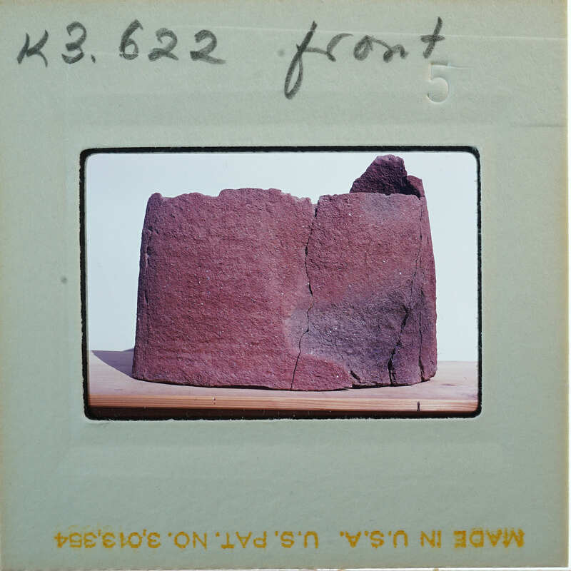 Broken base of terracotta figurine skirt from front.