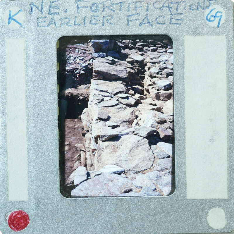 A photograph of a rock wall on a film strip with handwritten notes.