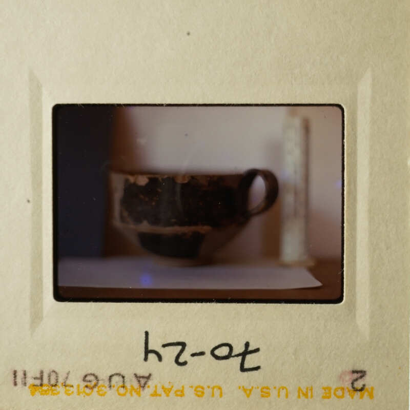 Two vintage photos on a table, showing two different scenes: a cup and saucer on a surface, and a close-up of a cup with a handle.