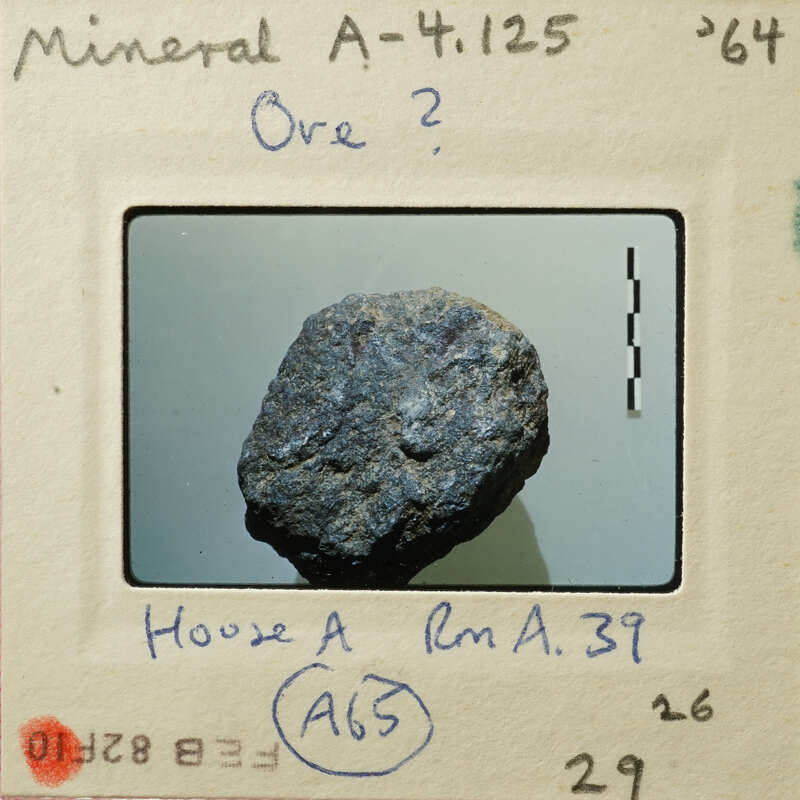 A photograph of a dark, rough-textured rock specimen.