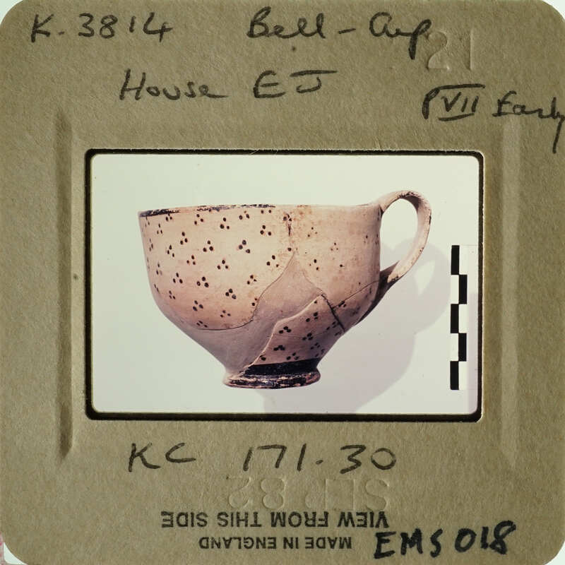 Ancient Greek cup with astronomical motifs and black stars on beige background.
