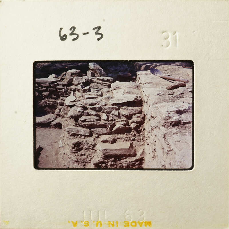 Old stone ruins with dirt and vegetation, captured on a film negative.