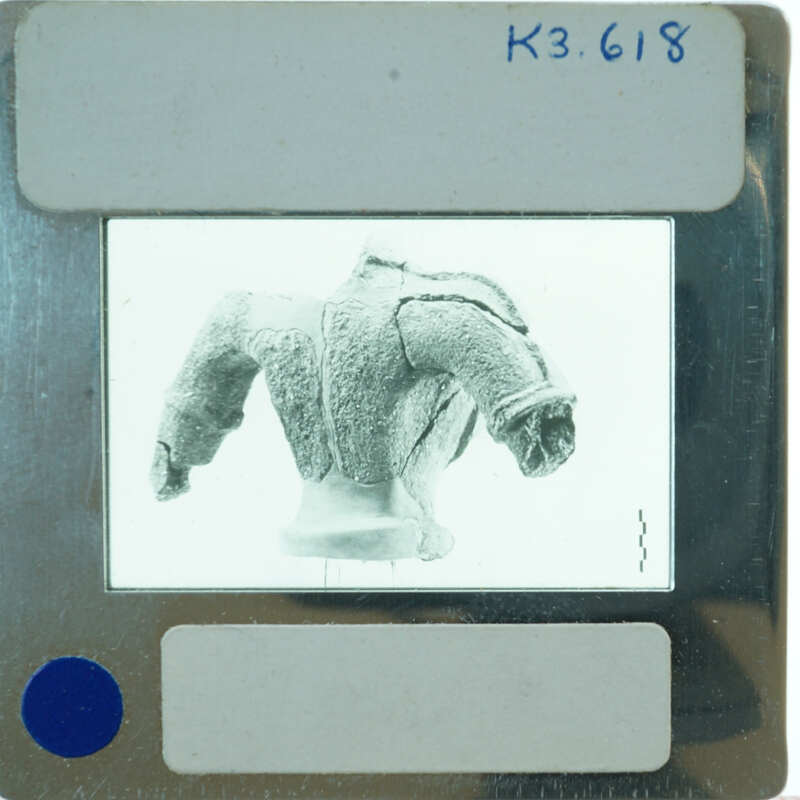 Terracotta figurine torso from back.