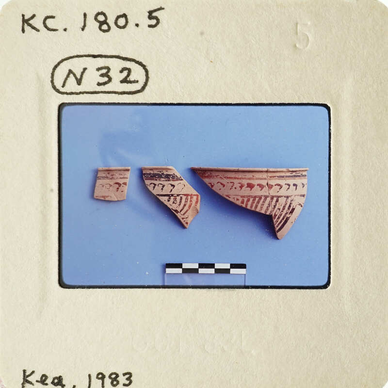 Two broken pieces of pottery on blue background with white lines and labels.