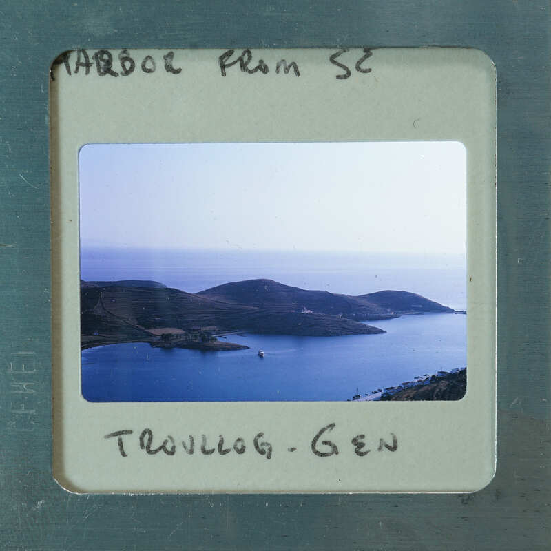 A photograph of a scenic bay with islands and boats, enclosed within an old film strip frame.