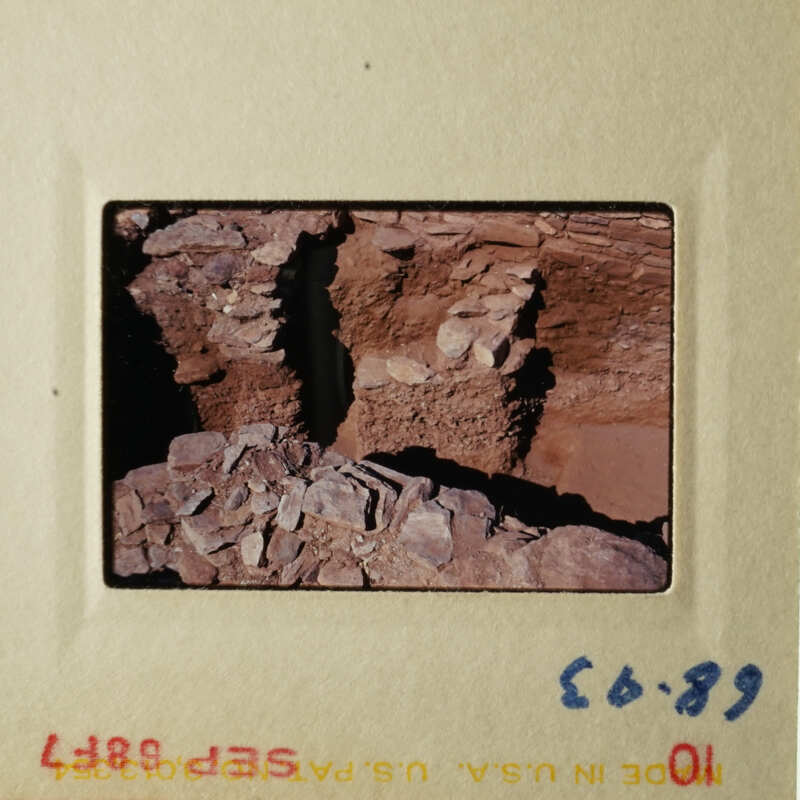 The photo shows an ancient stone structure, possibly ruins, with layers of rock and dirt.