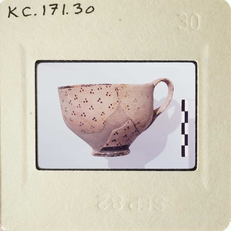 Old ceramic cup with spots on its surface.