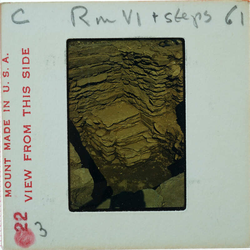 A photograph of a cave or rocky underground area with layers of rock and soil.