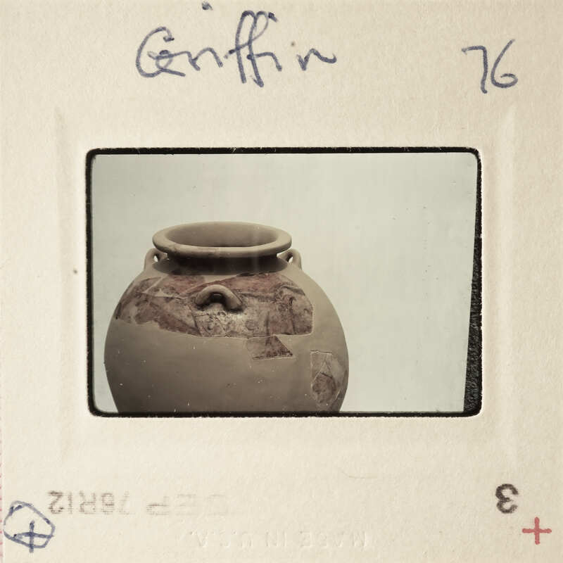 A photograph of a clay pot with markings and an image of a face on it, taken by Griffin.