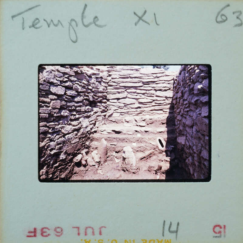 An old stone structure with a dirt floor and steps, possibly part of an ancient temple or ruins.