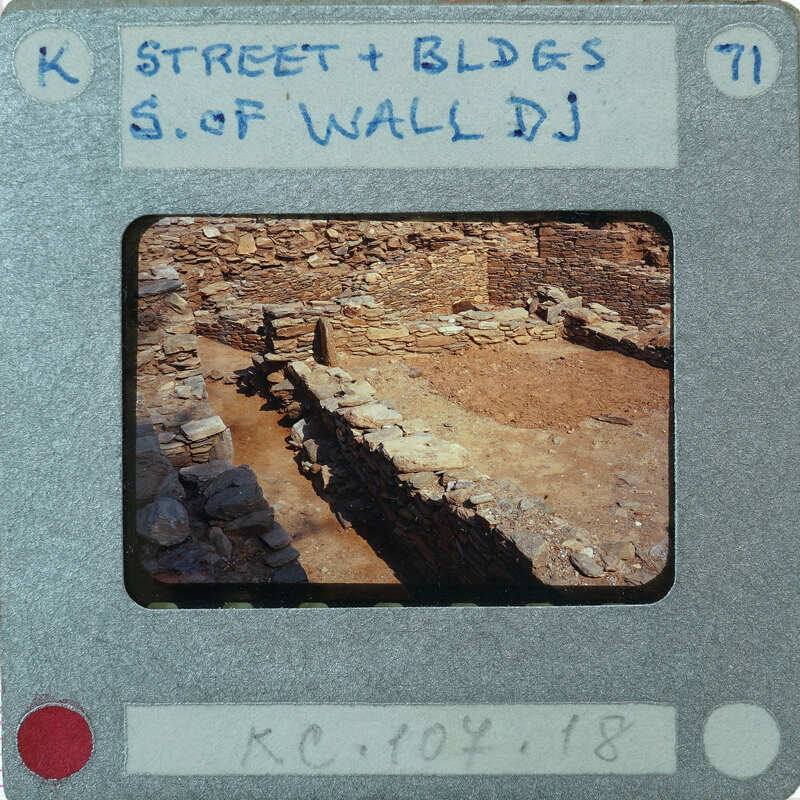 A photograph of an ancient stone wall with a label on the front.