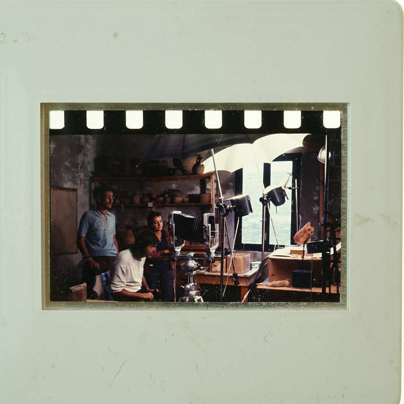 A vintage photo of a man and woman with film equipment.