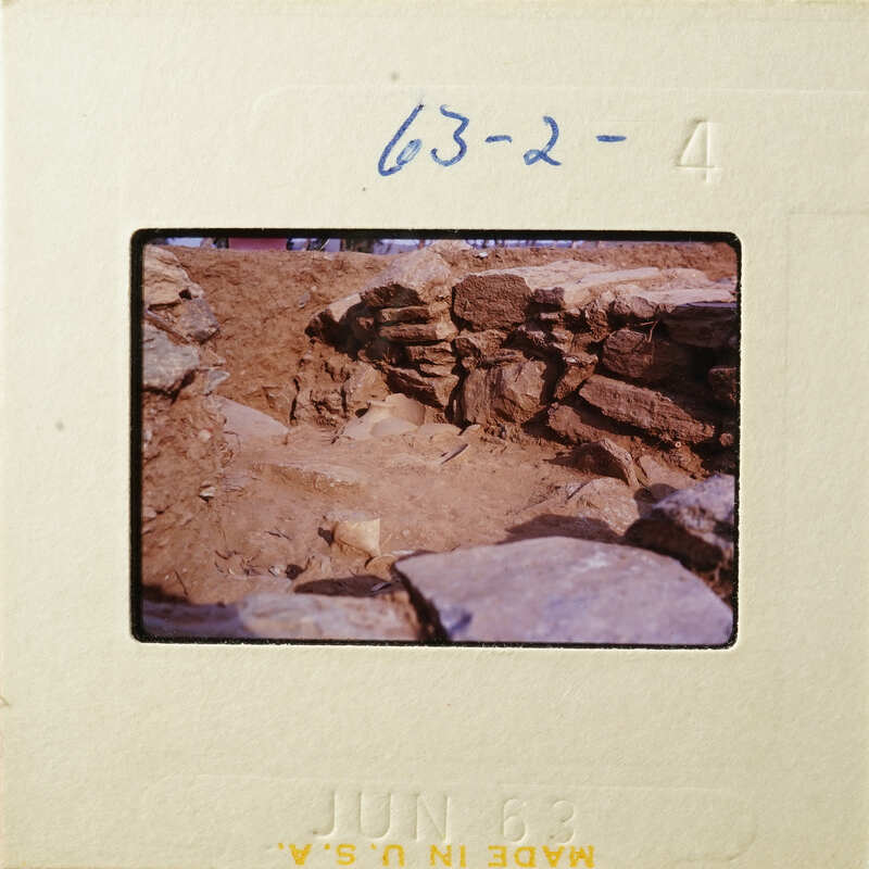 Dirt and rock formation with stone wall.