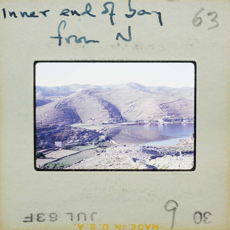 A vintage photo of a mountainous landscape with a body of water.