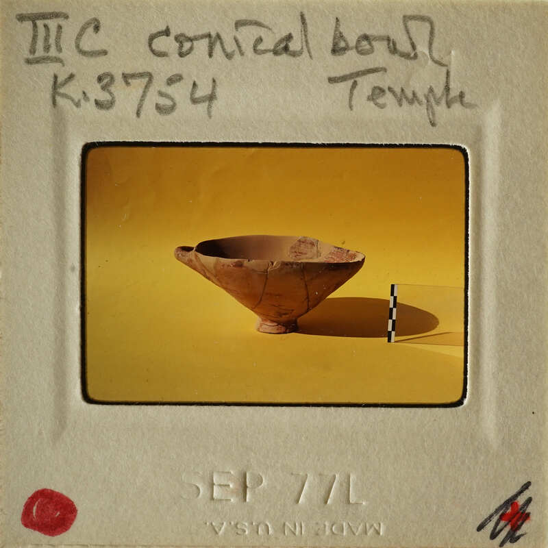 Ancient clay bowl on yellow background with measurement markings.