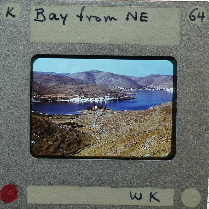A photograph of a scenic bay with mountains and water, framed by an old-fashioned film strip border.