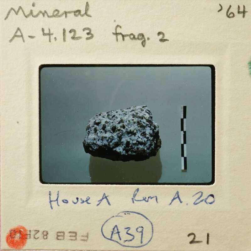 A photo of a mineral sample on a mount with labels and measurements.