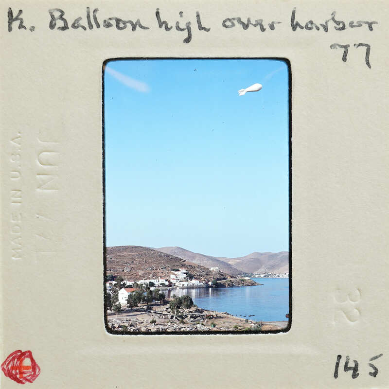 An old photograph of a coastal town with mountains and water, labeled with handwritten notes.