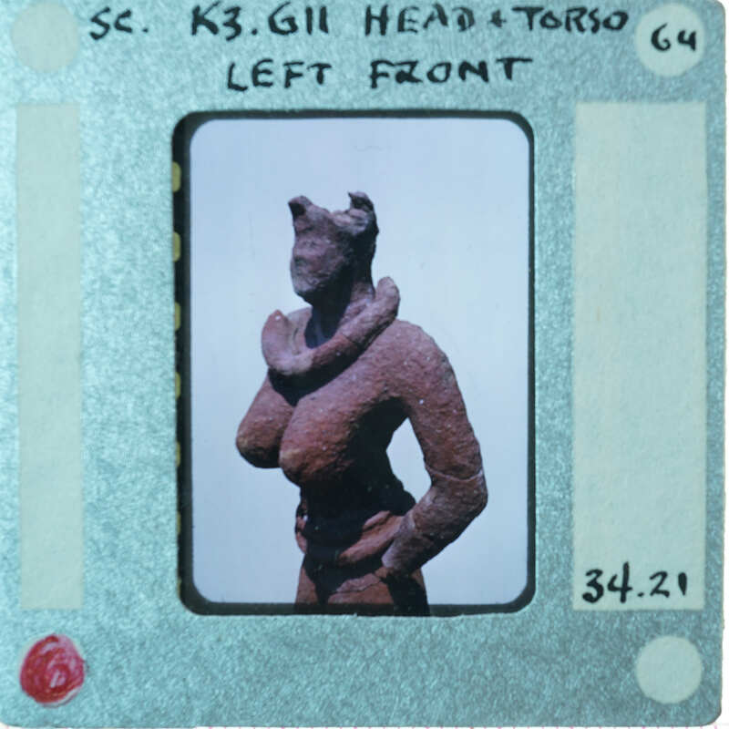 Torso and head of terracotta figurine from 3/4 view.