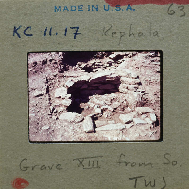 Ancient ruins with semi-circular stones and a dirt floor, probably from a grave.