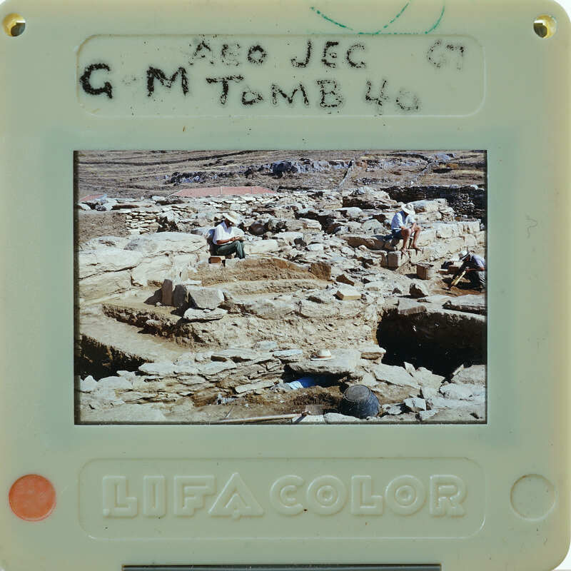 A photograph of an archaeological site with people working on excavation, displayed on a Polaroid camera.