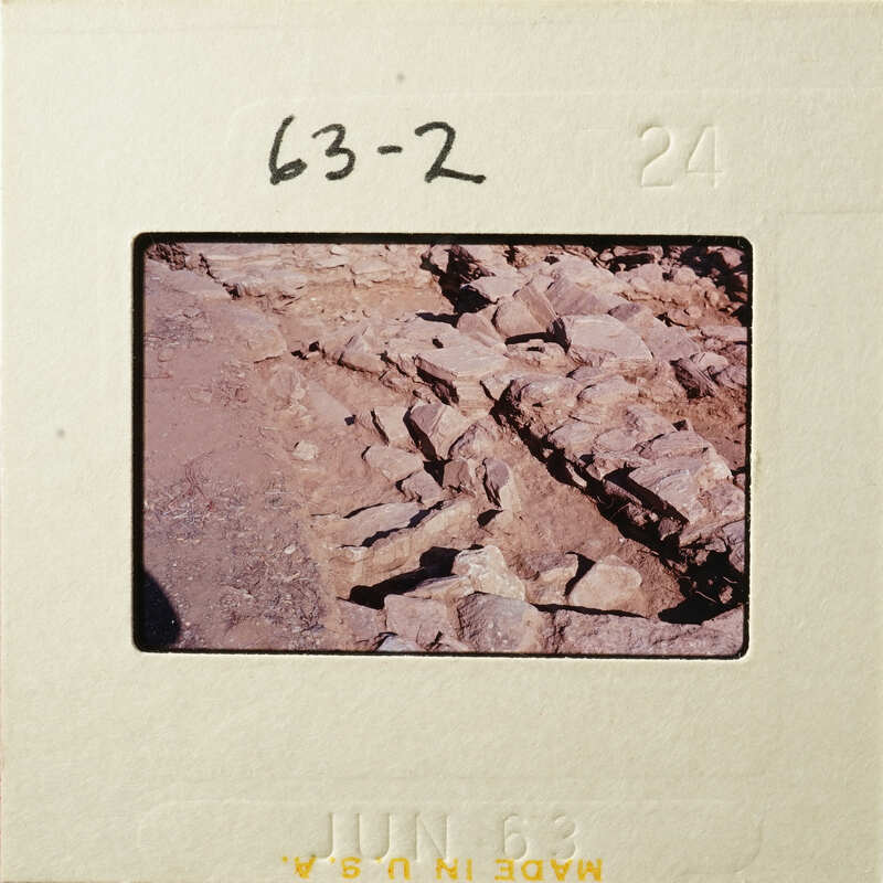 A photograph showing an outdoor scene with rocks and soil, possibly part of an archaeological excavation.