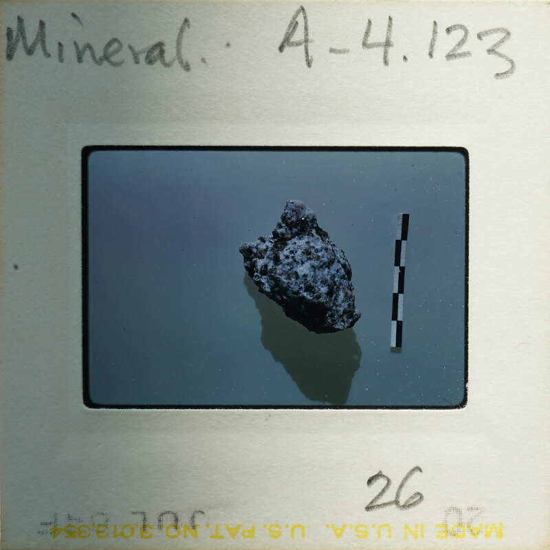 Slide of a rock with measurement lines on a background.