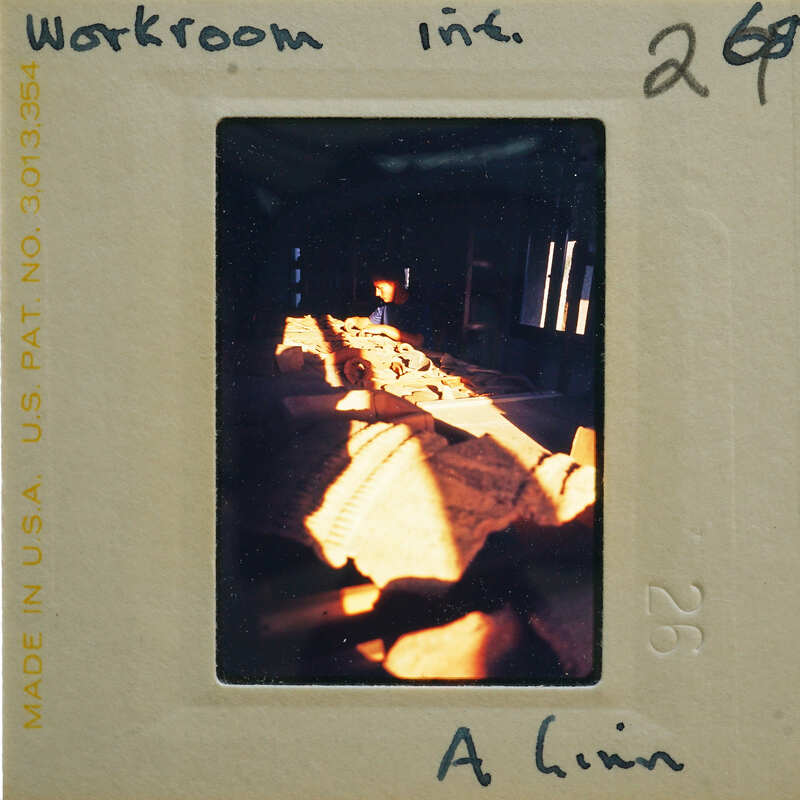 A vintage photograph of a room with sunlight streaming through windows, showing the negative and its details on a light table.