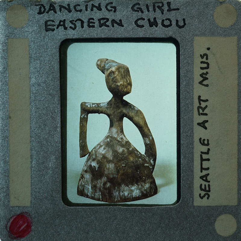 Small figurine of a dancing girl on an old film strip.