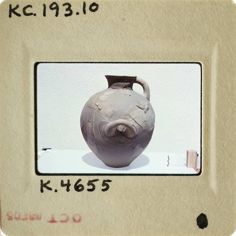 Ancient clay pot with handles and visible texture on display.
