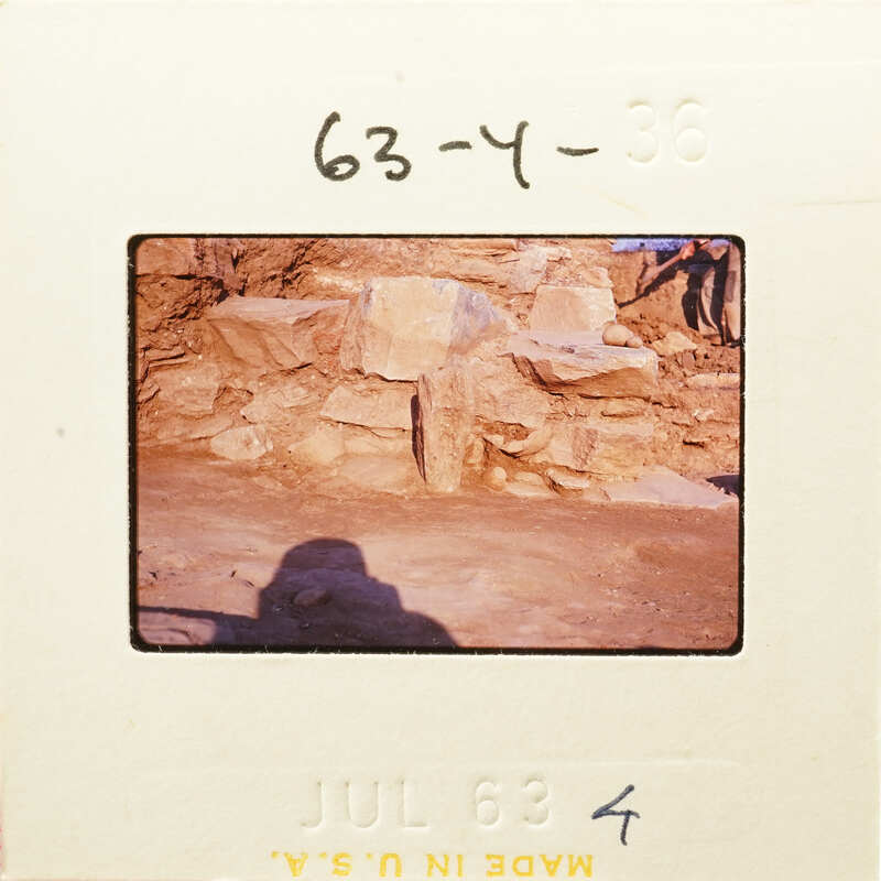 Old photograph of stone ruins with a person standing nearby, dated July 1963.