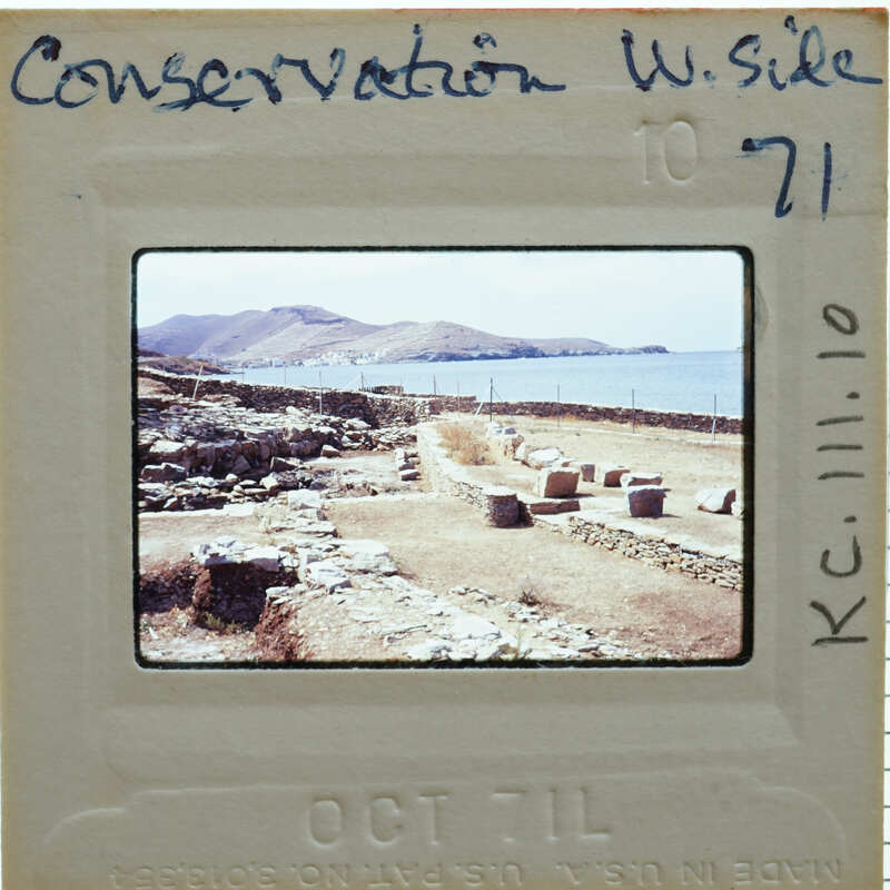 A slide of an ancient archaeological site with stone ruins and a body of water in the background, dated 1971.