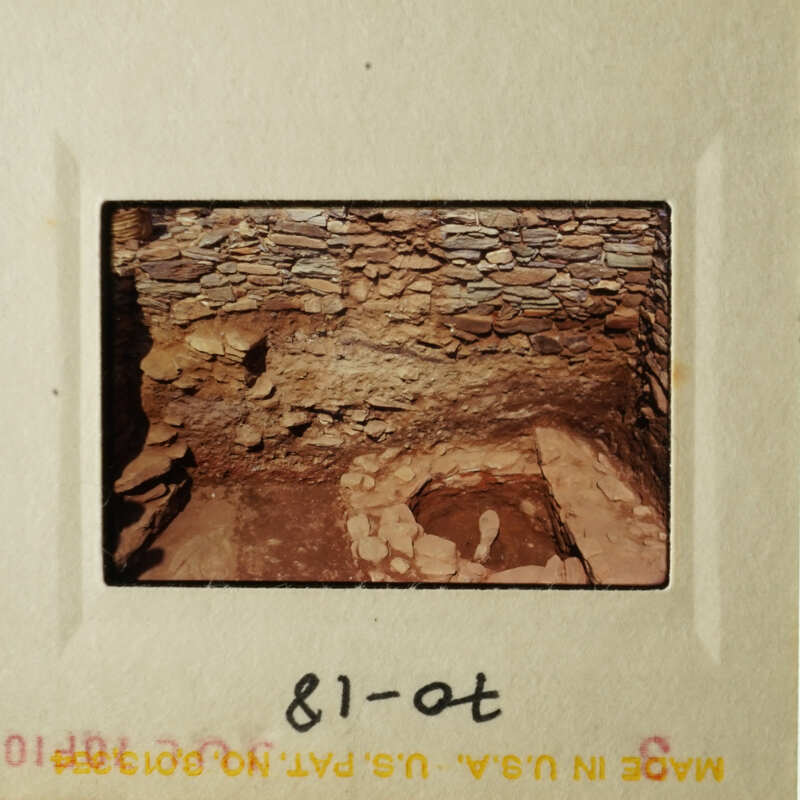The photo shows an ancient stone structure, possibly a cave, with a small opening on the right side and a large opening on the left.