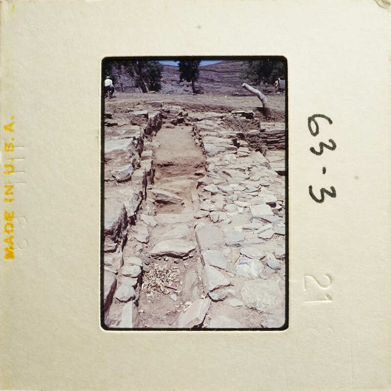 Ancient stone ruins with exposed layers and vegetation, captured on an old photograph.