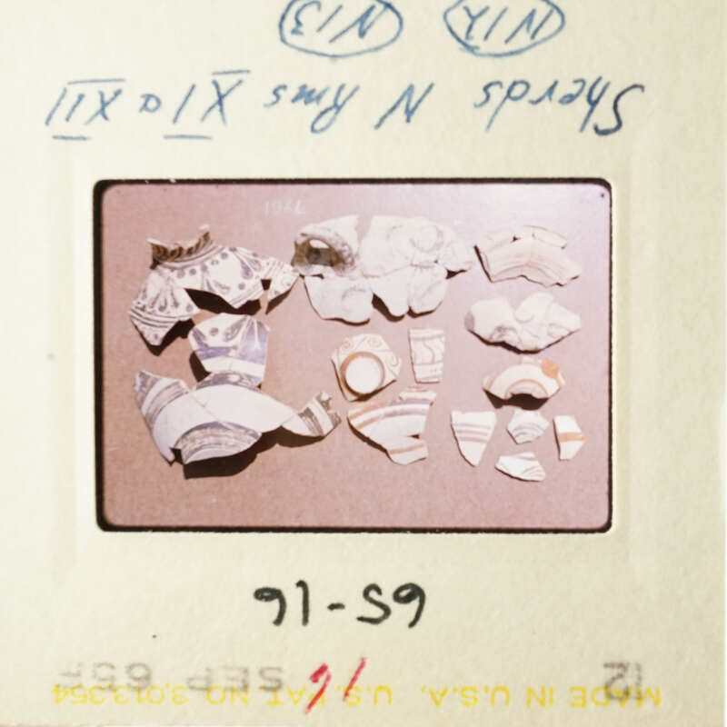 The image shows a collection of pottery shards on a table.