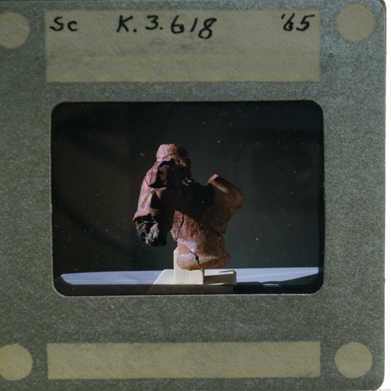 Terracotta figurine torso from side.