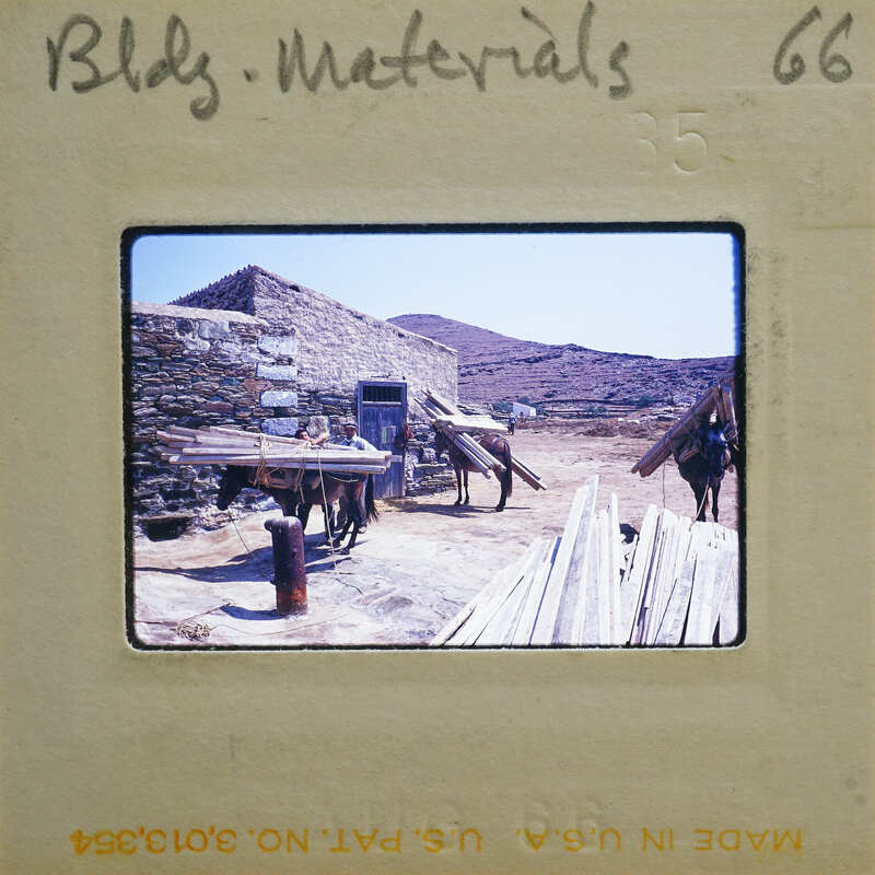 Old photograph of a rustic stone building with a horse and wooden beams.