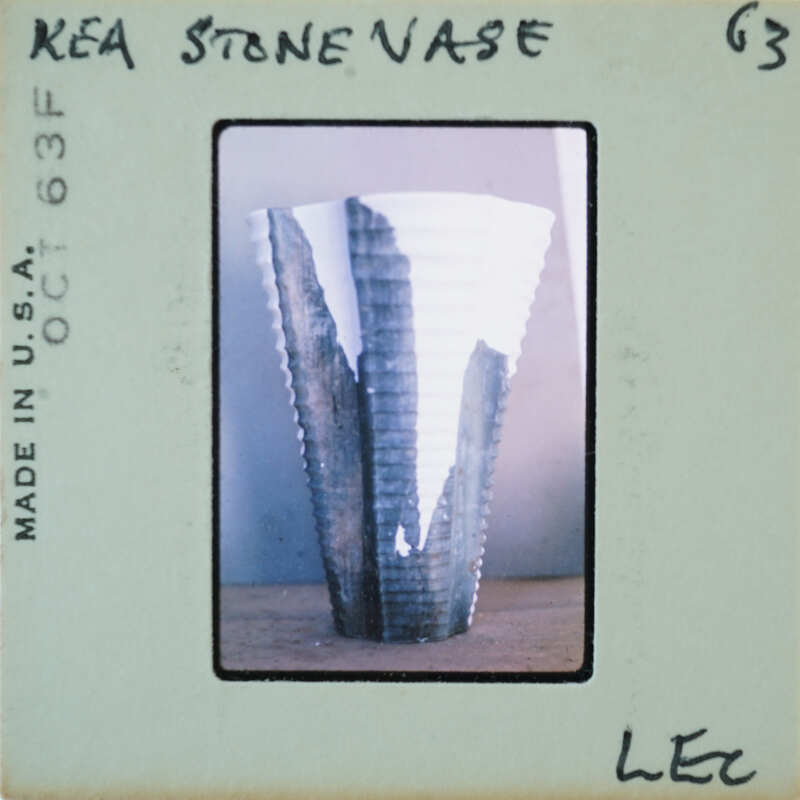 A photograph of a stone vase with jagged edges on a table.