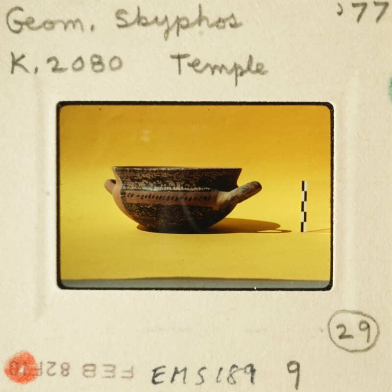 Ancient Greek vase on display with yellow background and black border.