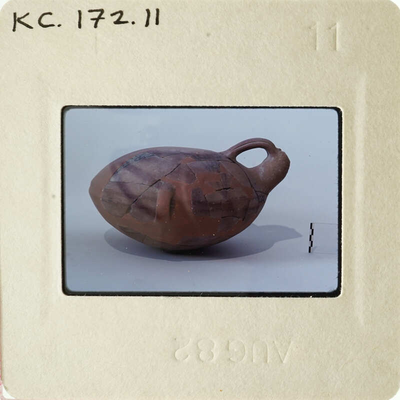 Ancient clay pot with lid, photographed on a white background.