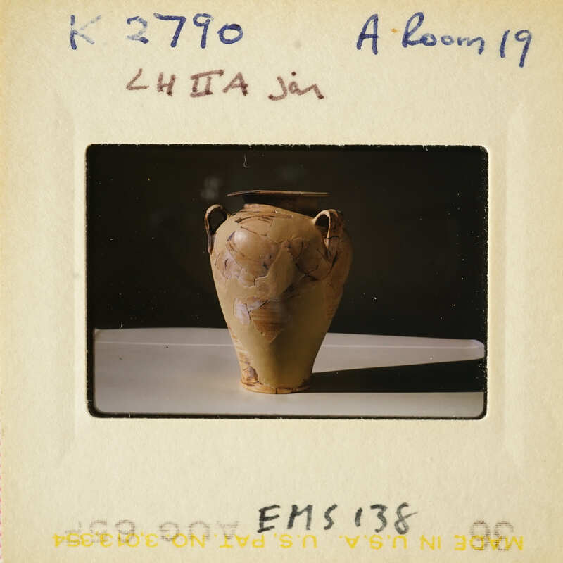 Ancient clay pot on display with visible markings and textures.