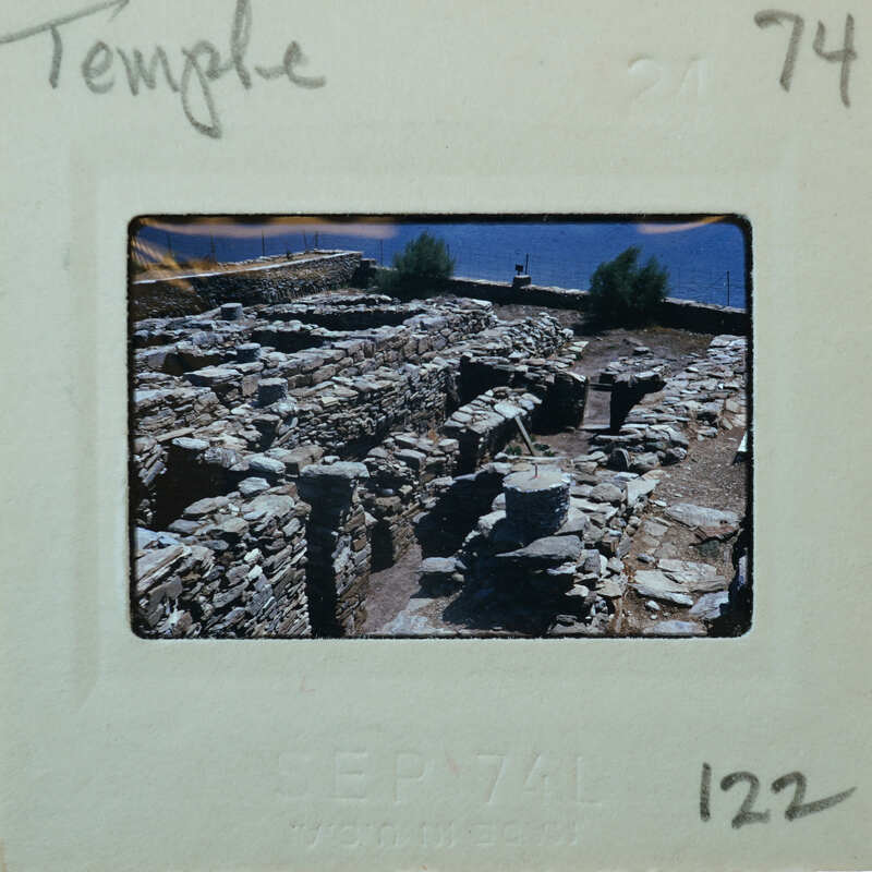 Parallel stone walls of Temple with trees and water to the upper right.