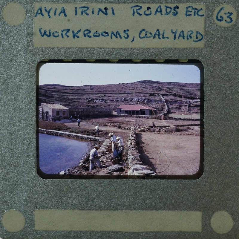 A vintage photograph of a rural landscape with stone walls and buildings, possibly a historical site or village.