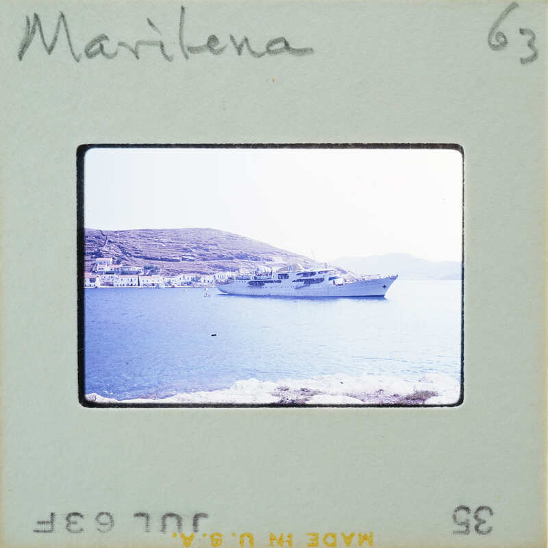 Photo of a boat on water with mountains in the background, taken from a vintage Polaroid camera.