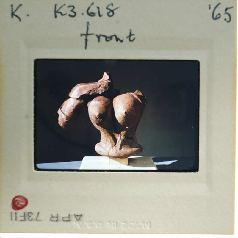 Terracotta figurine torso from front.