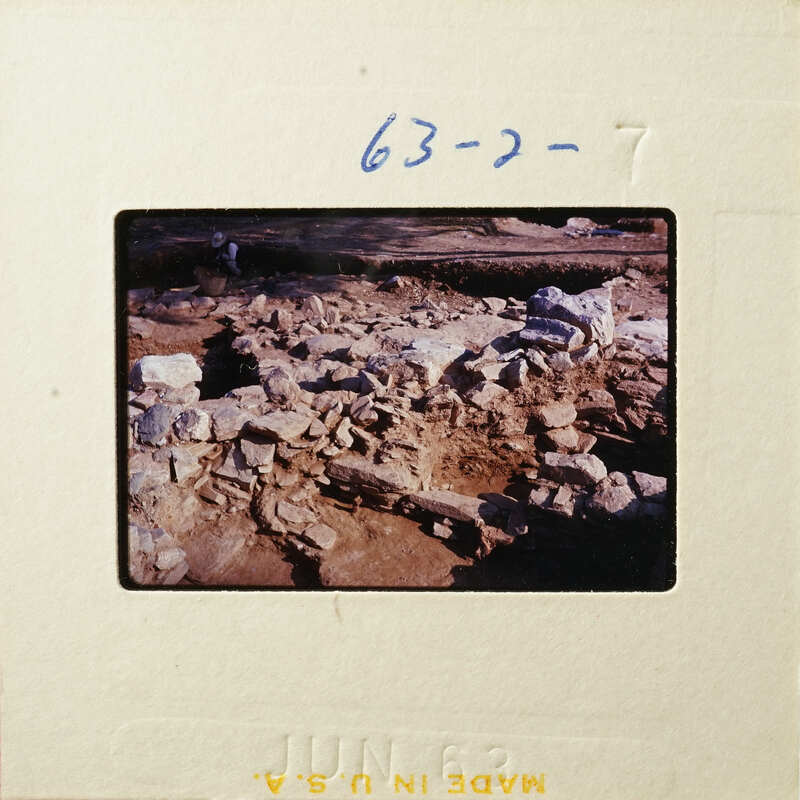 Ancient ruins with stone structures and dirt, partially excavated.