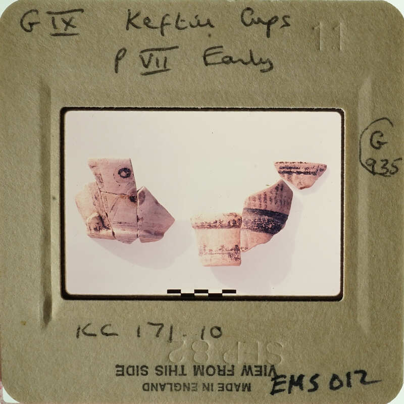 Photograph of ancient pottery shards with visible markings and textures.
