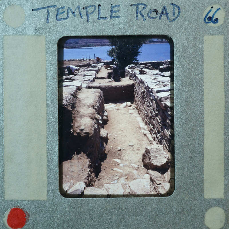 An old photo of a historical site with ruins and a body of water, printed on film strip paper.