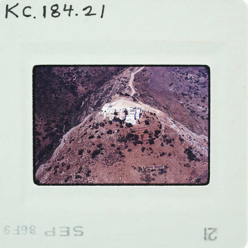 Aerial photograph of a mountainous landscape with a road and vegetation.