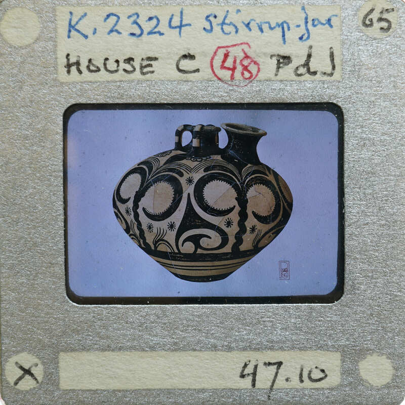 A photograph of a decorative stirrup jar with intricate patterns on it.